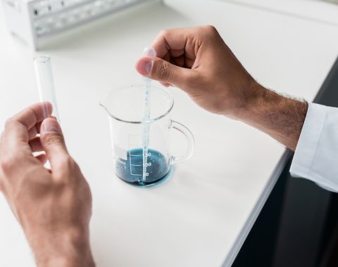 Cropped shot of professional scientist making experiment in chemical lab